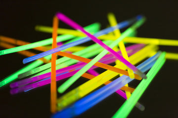 Pile of bright glow sticks on top of a black background
